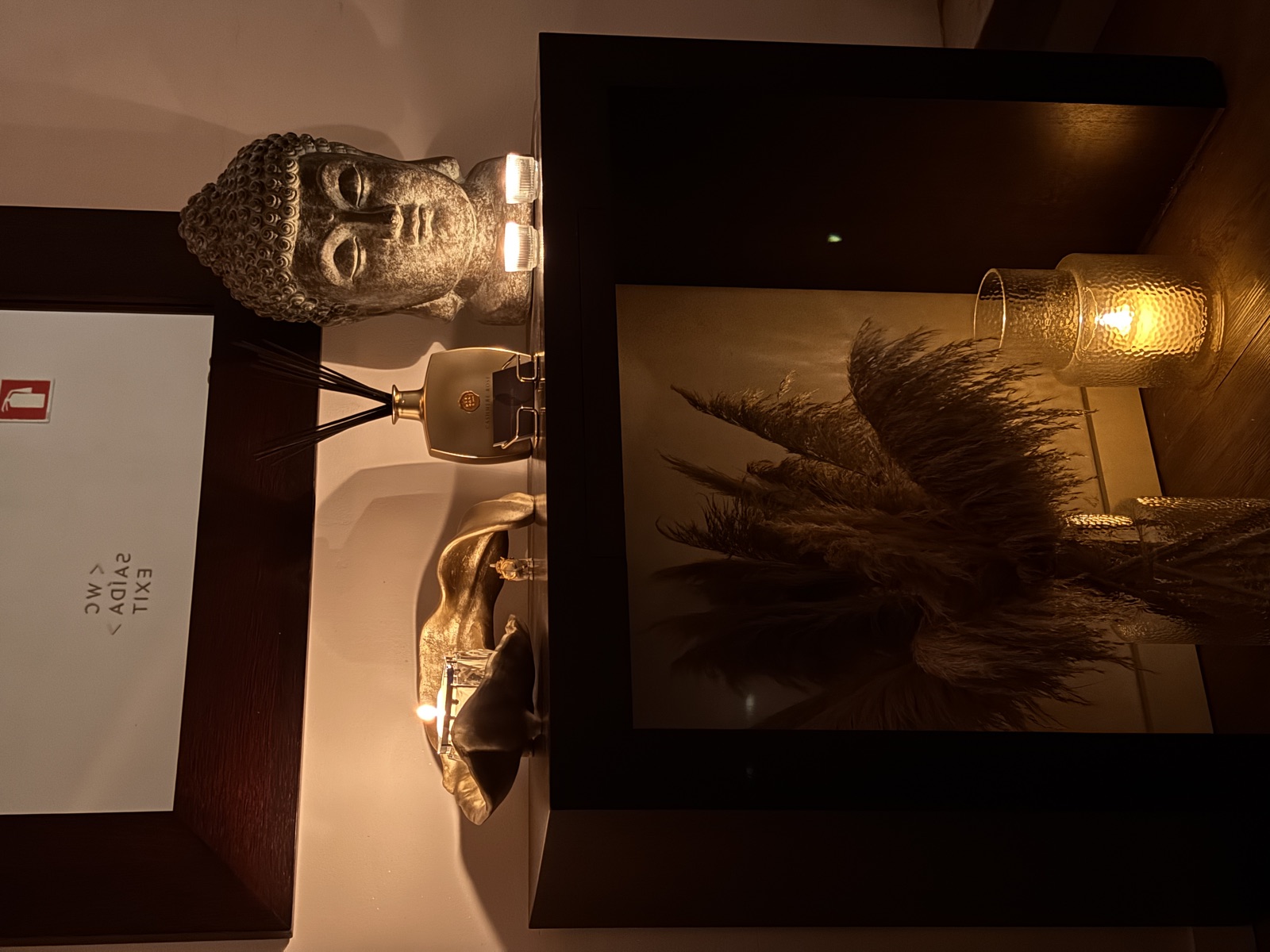 Sophisticated décor with a Buddha statue and candles on the console at The Tantric Flow in Lisbon