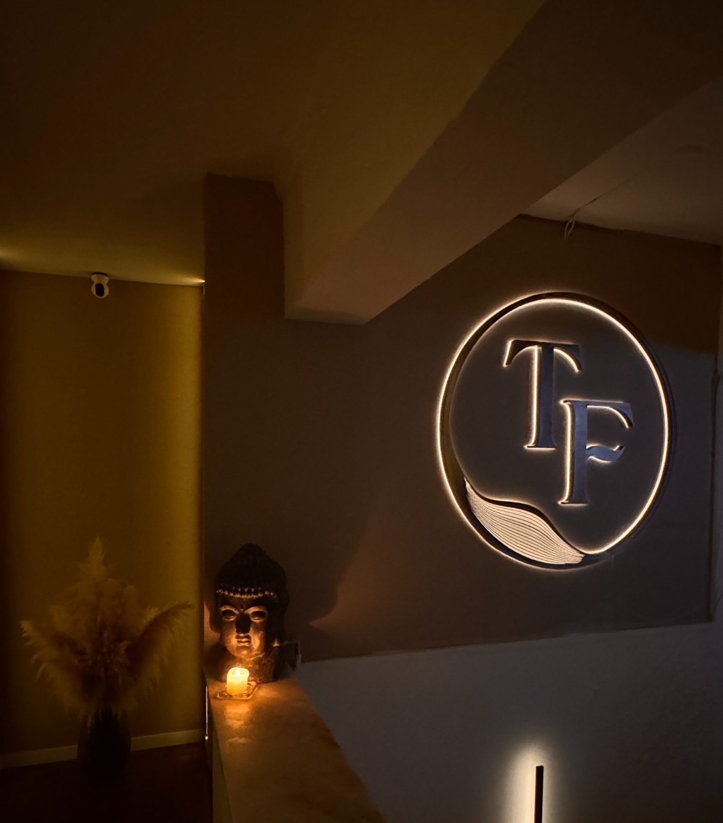 Illuminated circular TF logo inside The Tantric Flow in Lisbon
