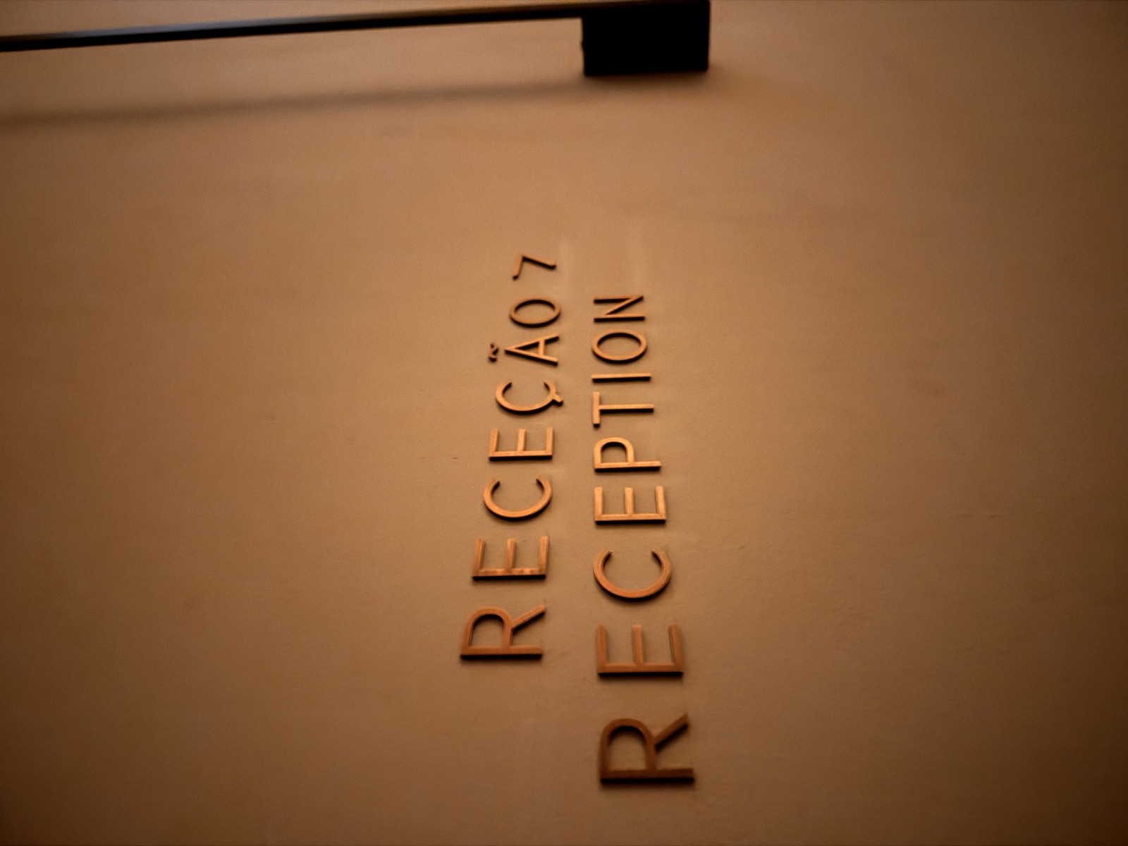 Gold RECEÇÃO / RECEPTION signage at The Tantric Flow reception in Lisbon